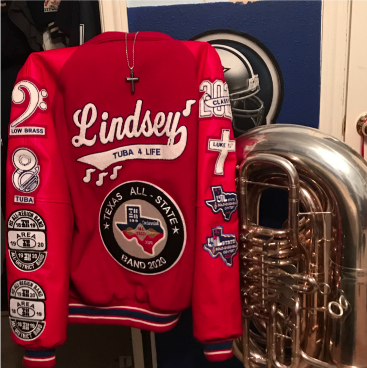 Lindsey's letter jacket sports patches showing his love for the tuba and his accomplishments in band, along with a cross with a Bible verse from Luke. 