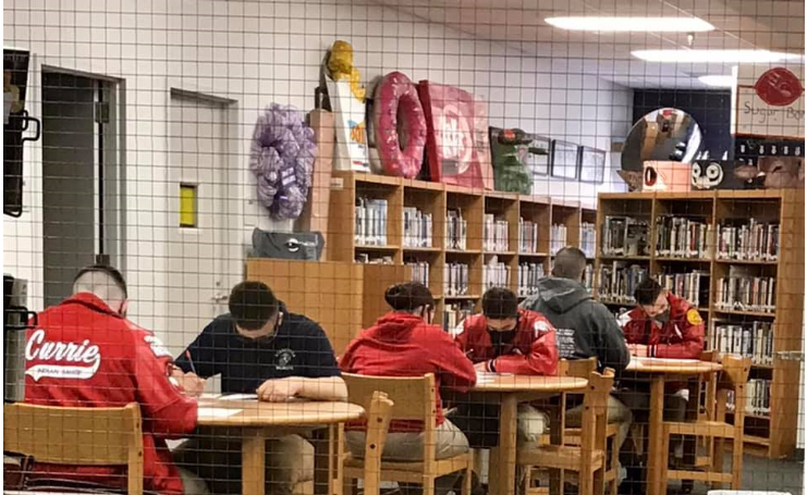 Six cadets work diligently on a timed test. 