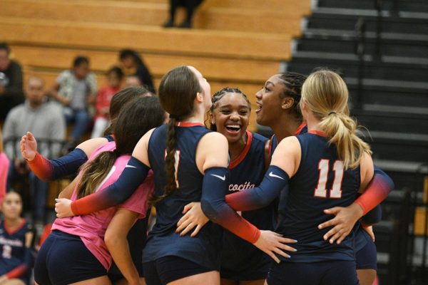 During the pink out game on Oct. 13, the team celebrates another point against Humble. This game caused celebration for a program sweep, senior Madisen Bailey made her 1,000th career assist, and it was freshman Jordan Morrow’s birthday. (Photo by Ainsley Ash)