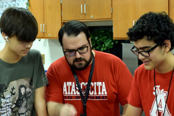 AP Biology teacher Adam Bowling works with sophomores Jacob Ayson and Amer Amer.