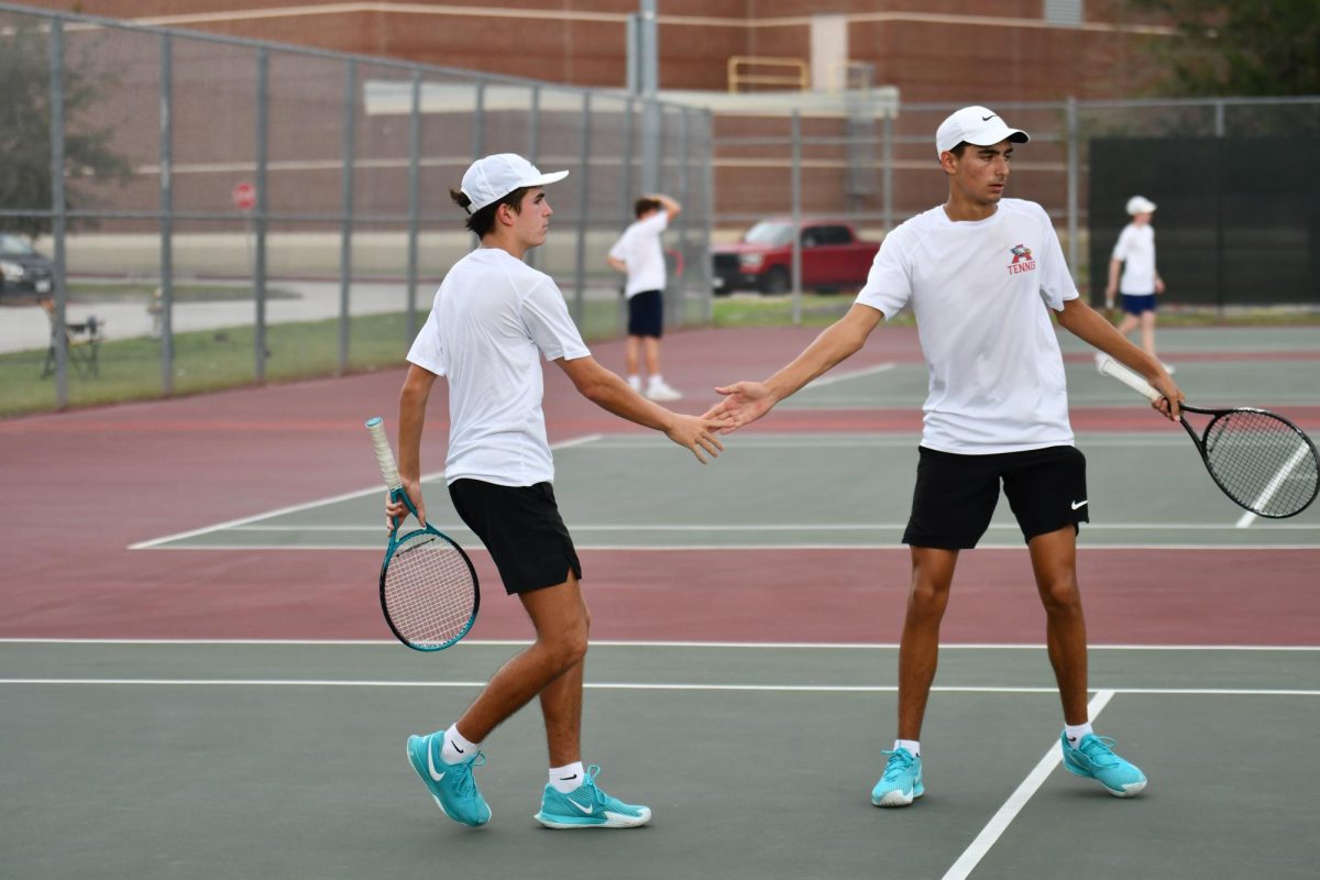 Senior Gabe Lopez and junior Nick Mateu high five each other after scoring agianst apponets 