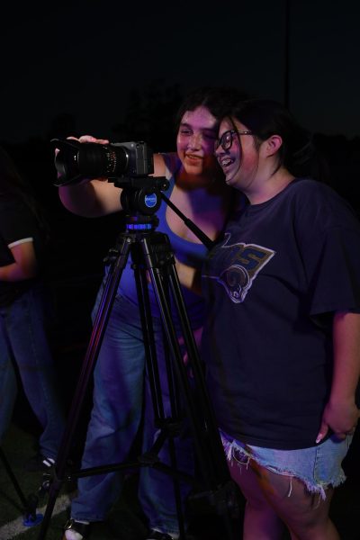 Seniors Mila Sutton and Tzeitel Agbayani film the hype video on the football field.