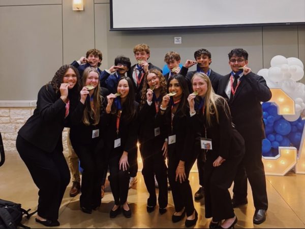 After a successful competition, all 12 DECA state qualifiers pose with their medals. (Photo provided by DECA Instagram)